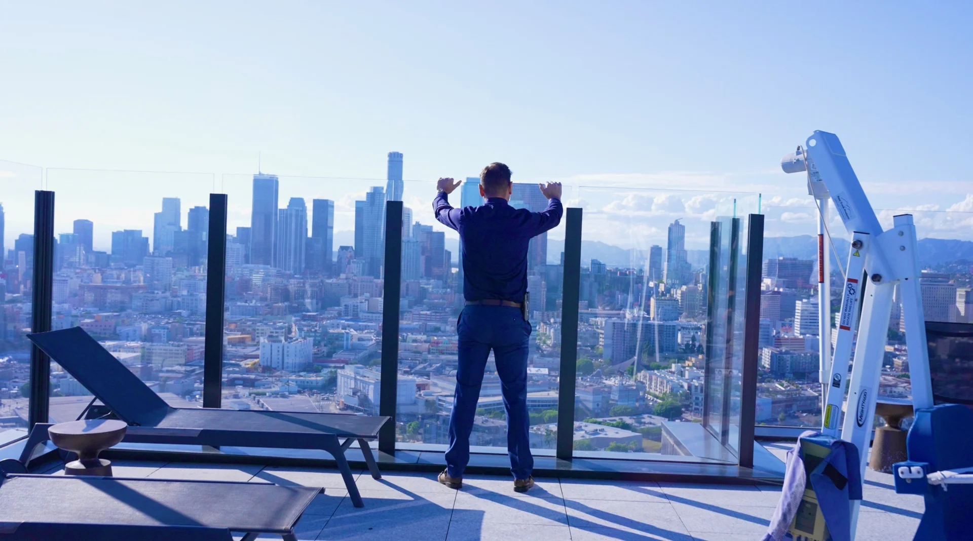 A man looks out over Los Angeles from a balcony